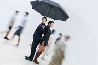 拿着雨伞的商务男女站在人群中