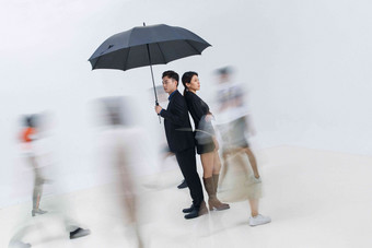 拿着雨伞的商务男女站在人群中