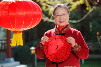 老年女人手拿窗花庆祝新年