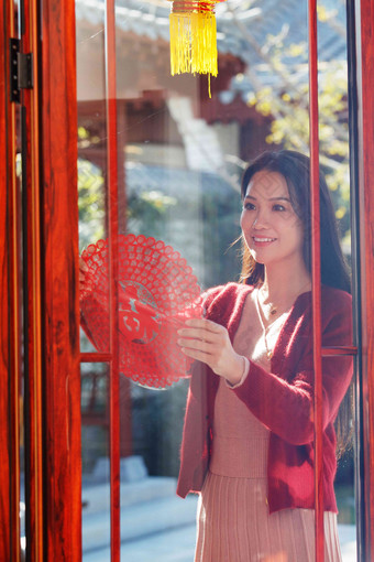 年轻女人过年贴窗花