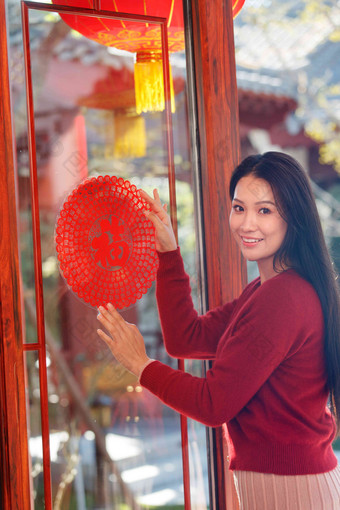 年轻女人过年贴窗花