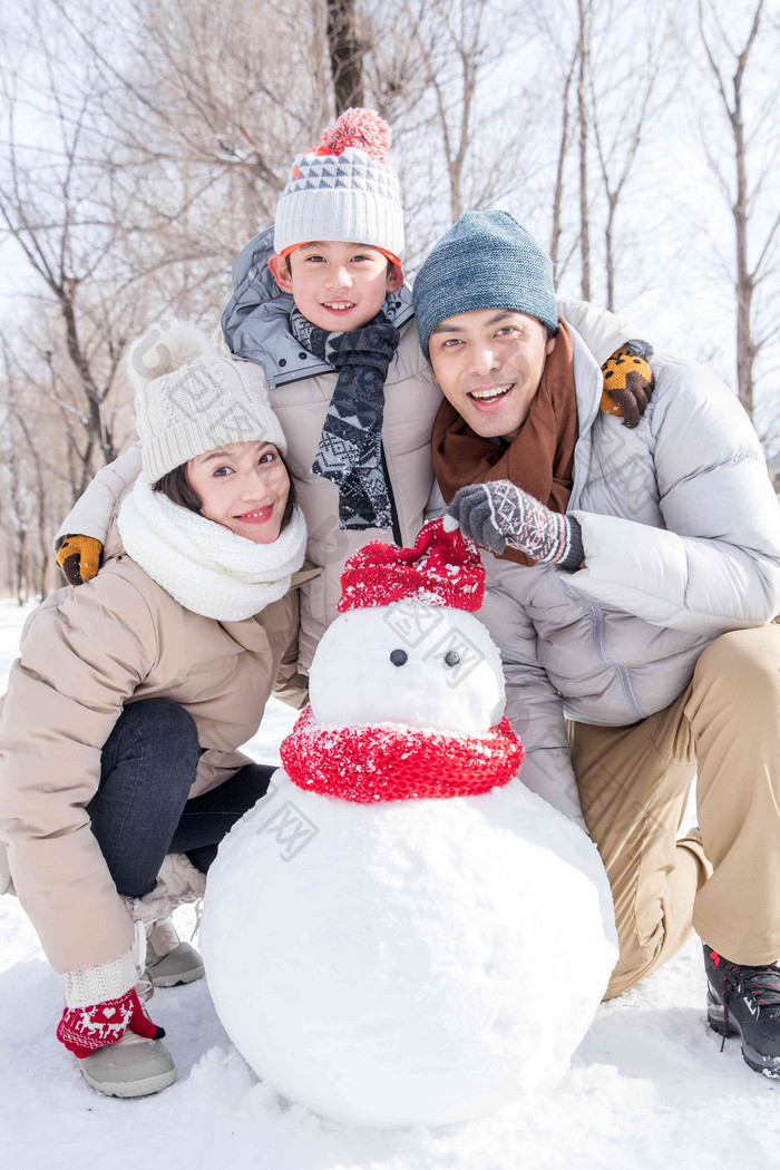 一家三口在雪地里堆雪人成年人氛围拍摄