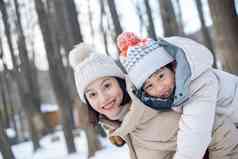 年轻妈妈带着孩子在雪地玩耍