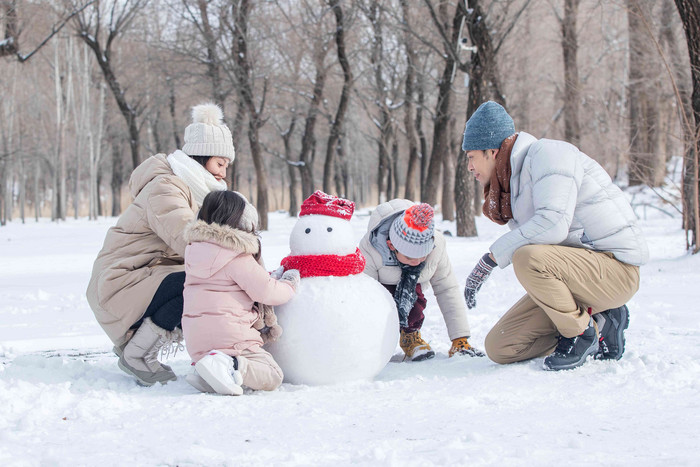 欢乐家庭在雪地里堆雪人雪人氛围影相