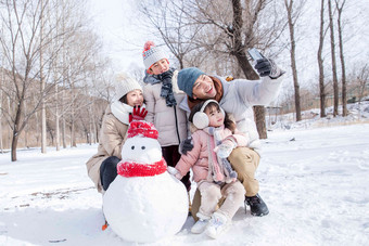 欢乐家庭在雪地里堆雪人