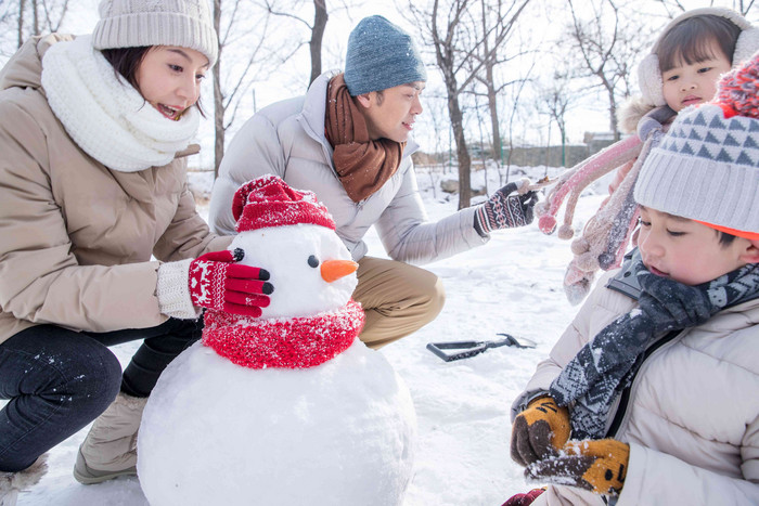 欢乐家庭在雪地里堆雪人相伴高清拍摄