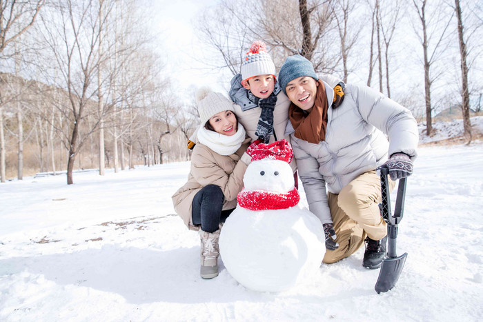 一家三口在雪地里堆雪人父亲写实场景