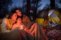 夜晚野外露营的东方家庭
