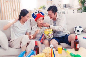 快乐的一家人边看电视边吃零食