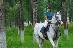 林间路上帅气的女孩骑着马