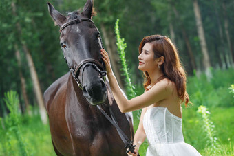 漂亮的年轻女人抚摸着马