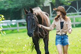 户外快乐的青年女人牵着马