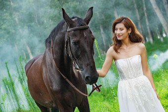 树林里漂亮的青年女人牵着马