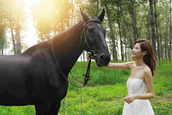 户外漂亮的青年女人牵着马