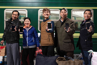 站在火车月台上展示手机的旅客