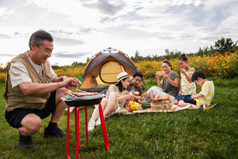 快乐家庭在郊外烧烤野餐