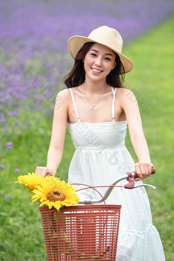 青年女人在花海里骑自行车