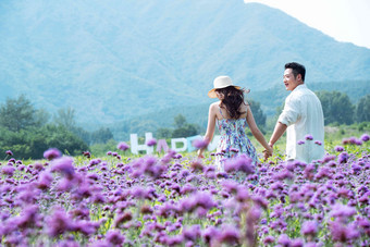 青年夫妇手牵手走在花海里