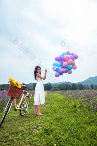 青年女人在<strong>花海</strong>里拿着气球