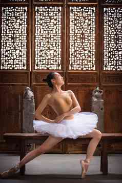 芭蕾舞演员坐在中式古典门前
