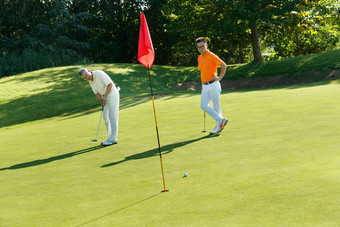 青年人和老年人打高尔夫