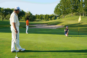 高尔夫球场上青年人和老年人一起打高尔夫