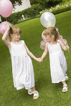 完整的长度可爱的伴娘气球持有手走花园
