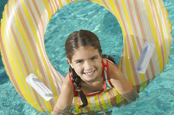 肖像可爱的小学女孩充气环游泳池