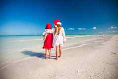 可爱的女孩圣诞节帽子有趣的异国情调的海滩