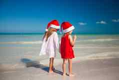 回来视图可爱的女孩圣诞节帽子异国情调的海滩