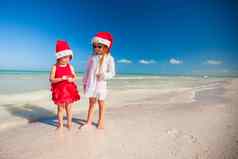 可爱的女孩圣诞节帽子异国情调的海滩
