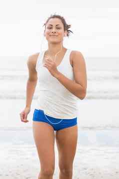 运动女人慢跑海滩相机