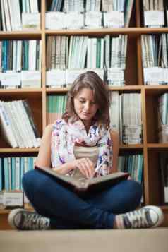 女学生书架上阅读书图书馆地板上