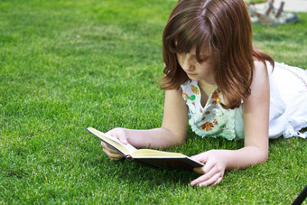 读年轻的美丽的女孩阅读书户外