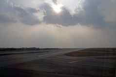 太阳破裂多云的天空机场跑道