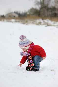 冬天婴儿女孩触碰雪球