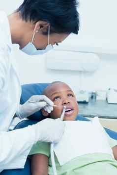 女牙医检查男孩牙齿牙医椅子
