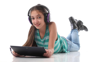 美丽的青少年女孩地板上强平板电脑电脑耳机