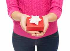 关闭女人粉红色的毛衣持有礼物盒子