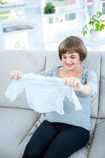 怀孕了女人持有<strong>婴儿衣服</strong>
