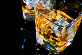 特写镜头前视图玻璃<strong>威士忌</strong>黑色的表格反射
