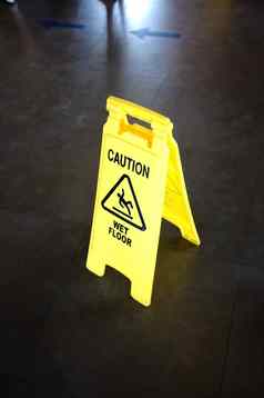 谨慎黄色的标志湿地板上警告地板上