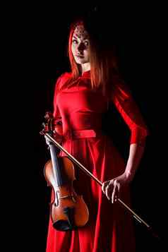 漂亮的年轻的女人持有小提琴