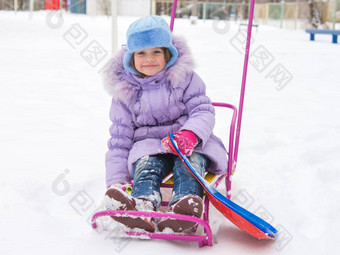 快乐的女孩坐着雪橇雪天气