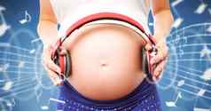 复合图像怀孕了女人持有耳机撞