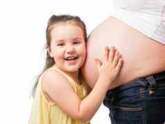 微笑女孩持有肚子怀孕了妈妈。