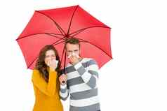 年轻的夫妇持有伞擦拭鼻子