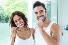 快乐年轻的夫妇刷牙牙齿