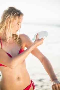 女人应用防晒霜乳液海滩