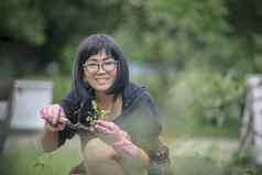 亚洲女人种植有机蔬菜首页花园人